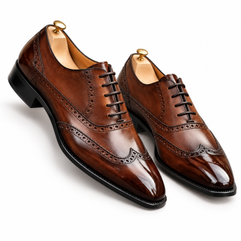 Men's cognac-brown genuine leather wingtip brogue Oxford-style dress shoes featuring polished leather uppers, decorative perforations, dark brown laces, elongated toe design, and contrasting black soles on a white background.