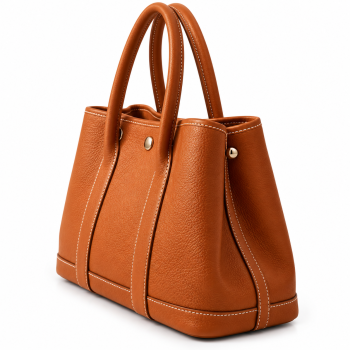 Angled front view of Mizon International women's genuine leather cognac-brown structured tote bag featuring a pebbled leather texture, two rounded handles, vertical front panels, silver-tone accents and contrast stitching.