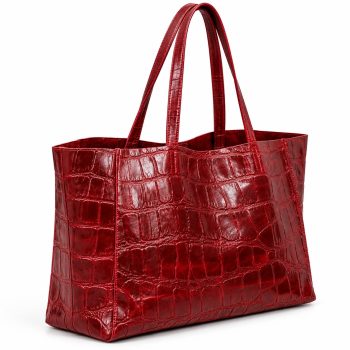 Angled side view of Mizon International women's burgundy genuine leather tote bag showing the glossy crocodile-embossed pattern, gusseted side panel, rectangular base and long shoulder handles.