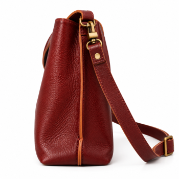 Front view of Mizon International women's reddish-brown genuine leather bucket shoulder bag featuring a pebbled texture, curved short handle, long strap with adjustment buckle, antique gold-tone fittings and minimalist rectangular body.