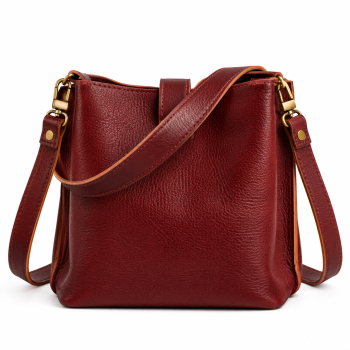Front view of Mizon International women's reddish-brown genuine leather bucket shoulder bag featuring a pebbled texture, curved short handle, long strap with adjustment buckle, antique gold-tone fittings and minimalist rectangular body.