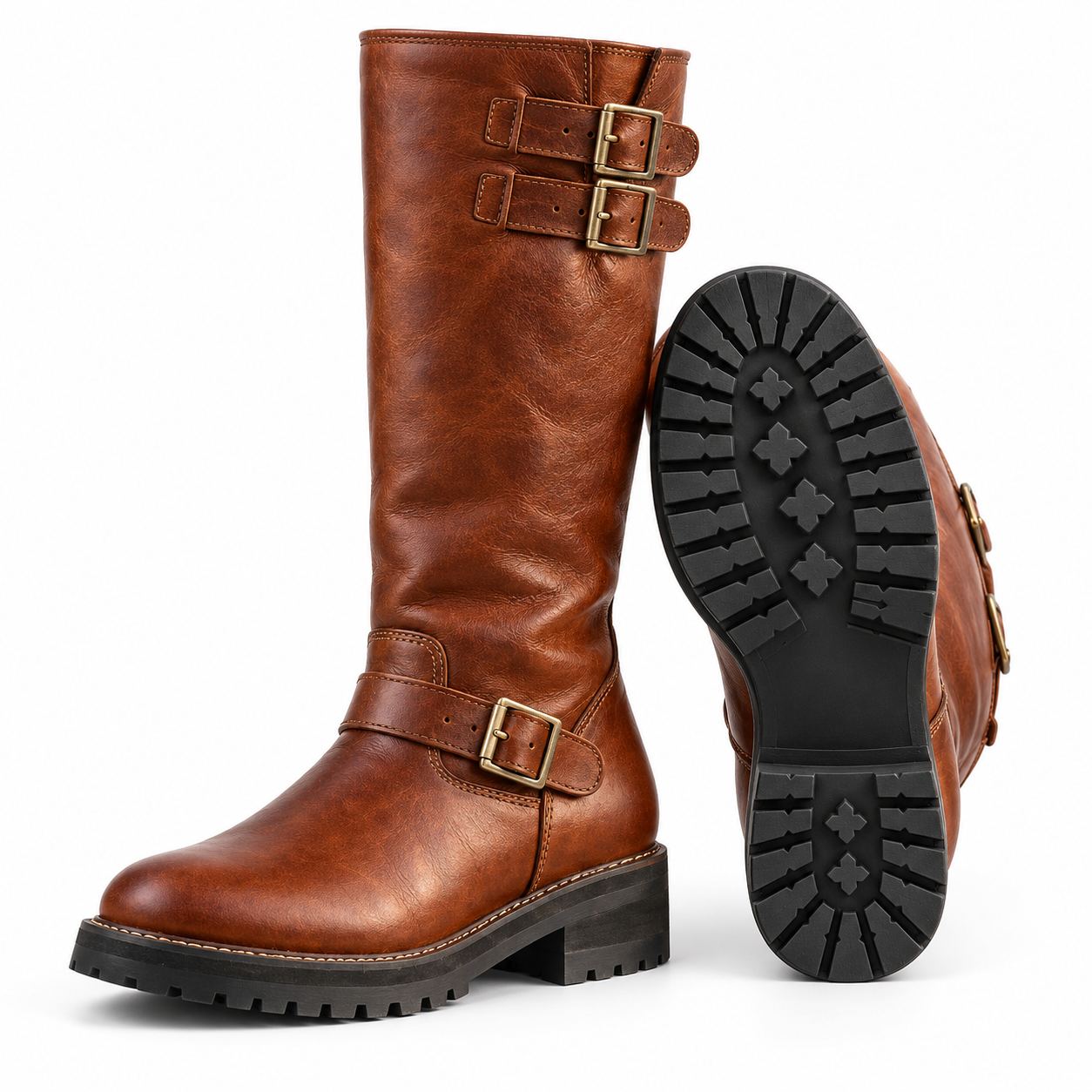 Three-quarter side view of one pair of Mizon International vintage cognac-brown biker boots with genuine leather uppers, tall shafts, antique brass-tone buckle straps, rounded toes, contrasting tan stitching, and thick black lug-pattern soles against a white background.