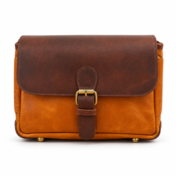Front view of Mizon International genuine leather two-tone satchel bag featuring a dark chocolate-brown fold-over flap, cognac-tan body, central buckle-style leather strap, antique gold-tone hardware and visible base feet.